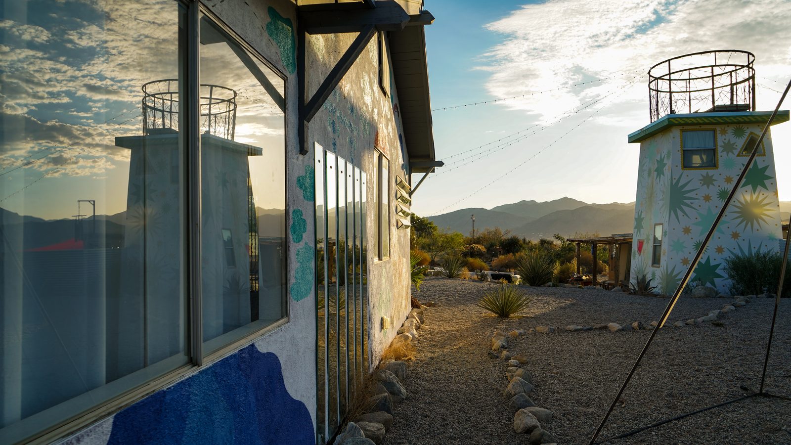 Golden hour light washing over the painted buildings and star tower with the mountains stretching beyond